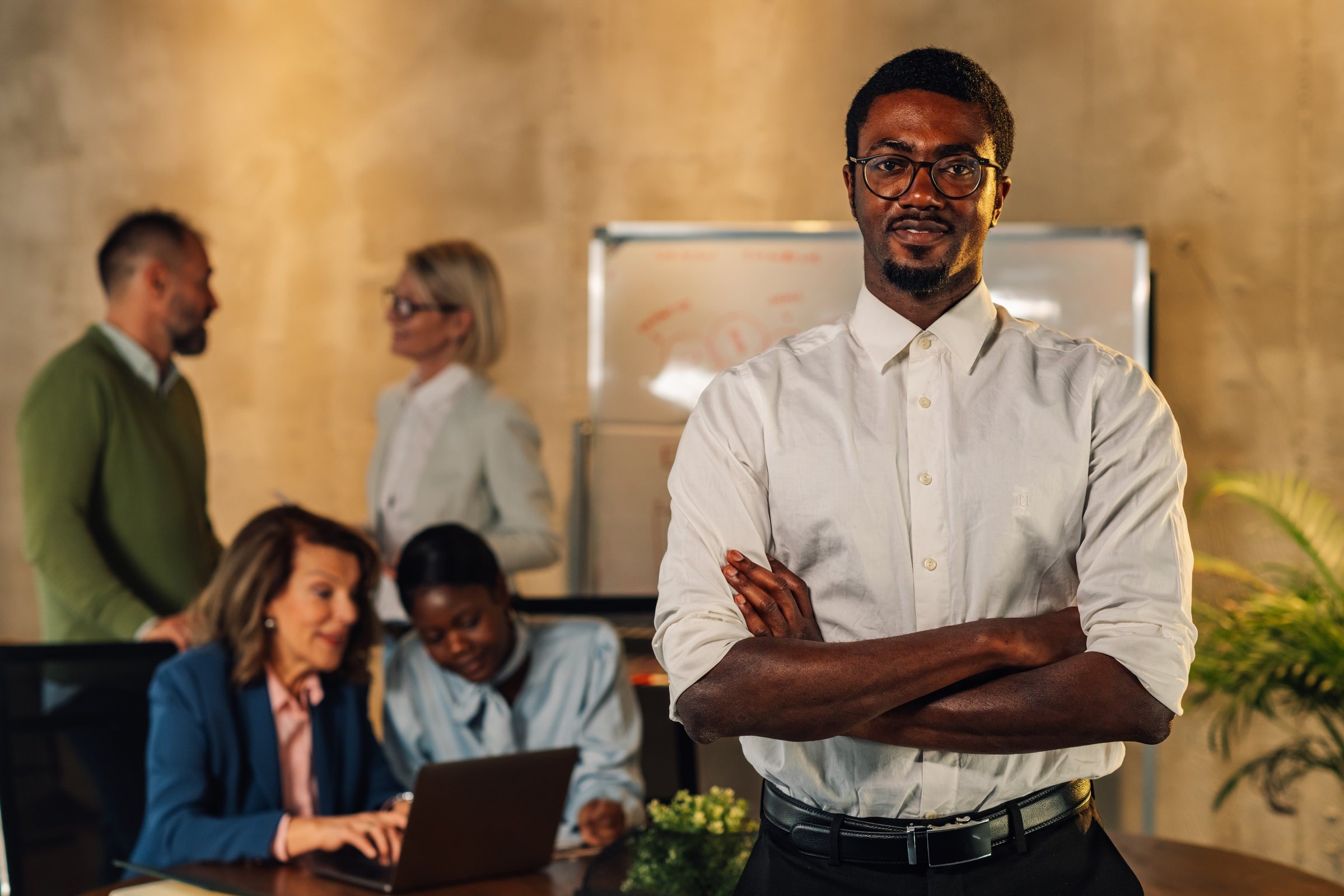 A business leader with his team at work behind him